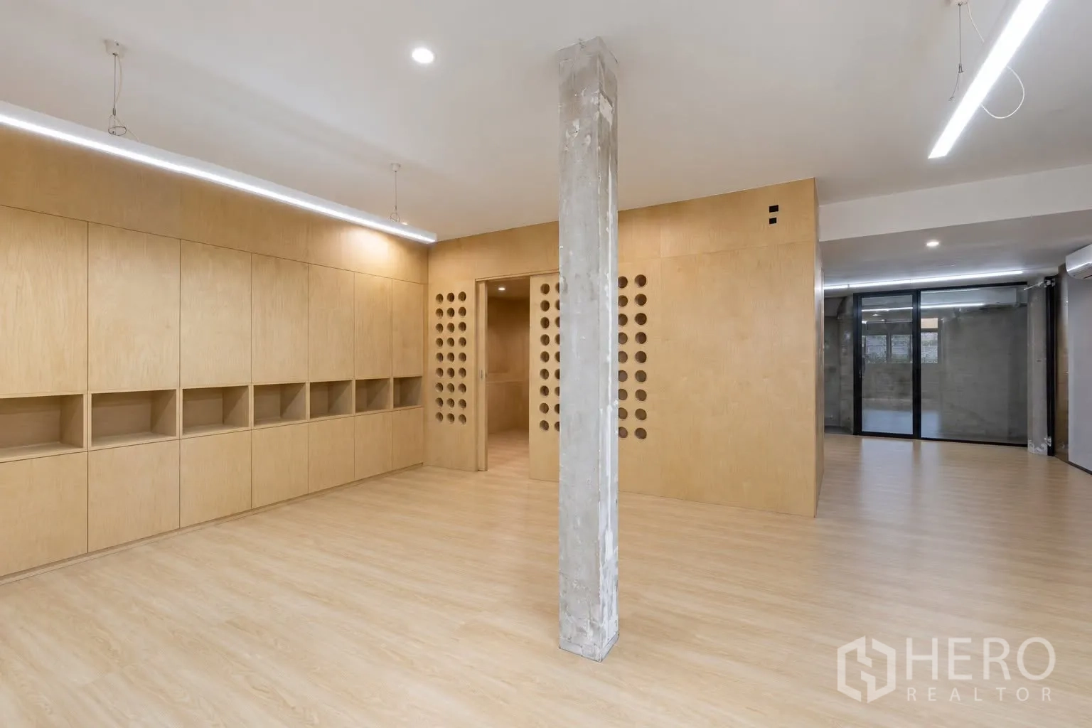 零售空间 for rent in Watthana, Bangkok - 开放空间，内置木质柜体与中央混凝土柱。