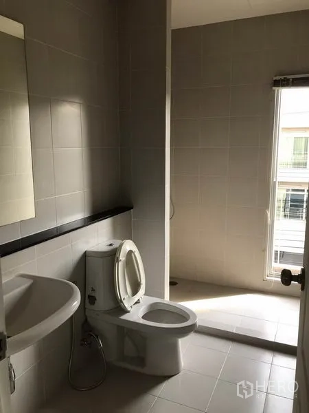 Townhouse for rent in Suan Luang, Bangkok - Secondary bathroom with walk-in shower, toilet and tall window.