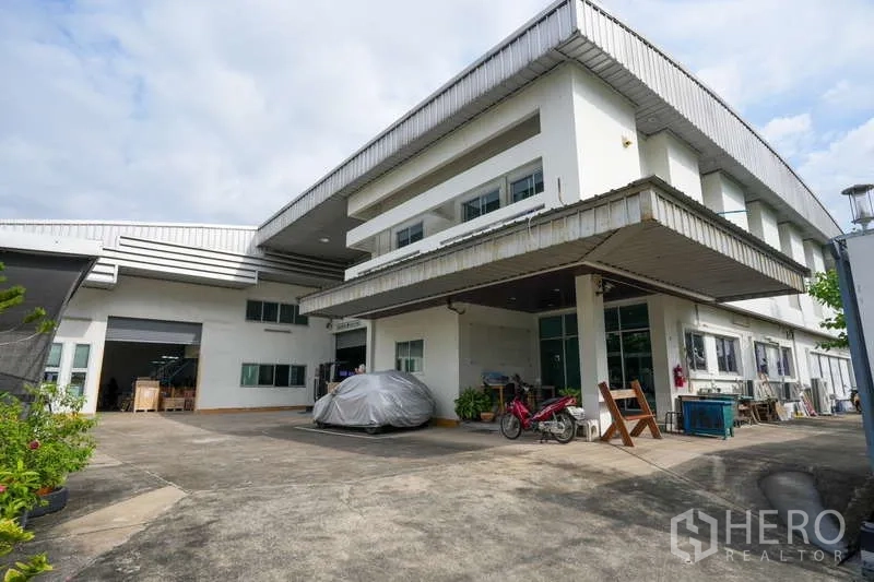 Warehouse for rent in Bang Khen, Nonthaburi - Two-storey warehouse with attached office, covered loading bay and wide concrete driveway in Nonthaburi.