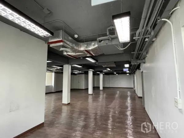 Office Space for rent in Ratchathewi, Bangkok - Open-plan office with exposed ceiling ducts, square columns and fluorescent lighting.
