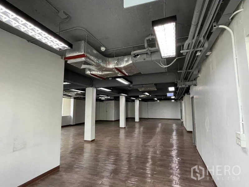 Office Space for rent in Ratchathewi, Bangkok - Open-plan office with exposed ceiling ducts, square columns and fluorescent lighting.