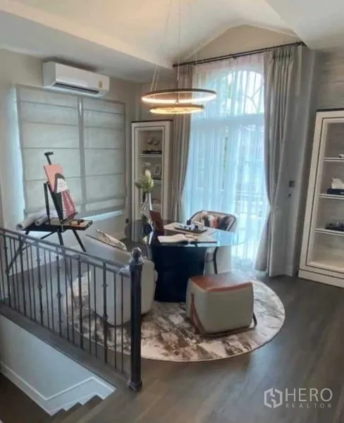 Detached House for rent in Bang Khen, Bangkok - Bright mezzanine sitting area beside the staircase with a round rug and modern pendant light.