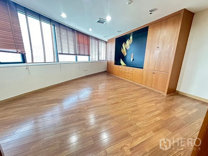 Office Space for rent - Private office with built-in cabinetry, feature wall, wide windows and hardwood floor.