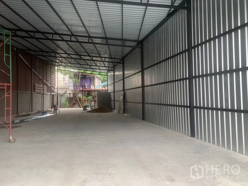 Warehouse for rent in Bang Kapi, Bangkok - Spacious warehouse interior with high steel roof, corrugated walls and concrete floor.