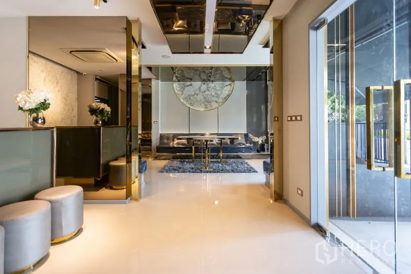 Townhouse for rent in Bang Phli, Samut Prakan - Elegant entrance hall with glass doors, gold accents and a marble feature wall.