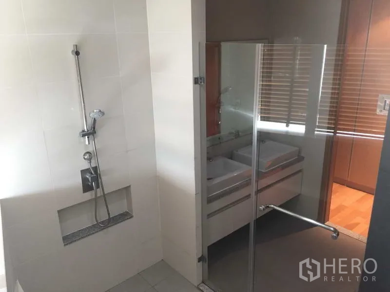 Condominium for sale in Khlong Toei, Bangkok - Contemporary bathroom with glass shower enclosure and double vanity outside the wet zone.