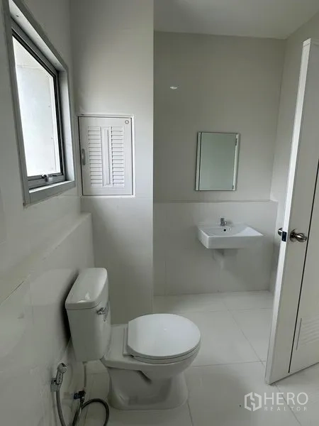 Factory for rent in Khlong Luang, Pathum Thani - Modern bathroom with window, toilet and wall‑mounted sink