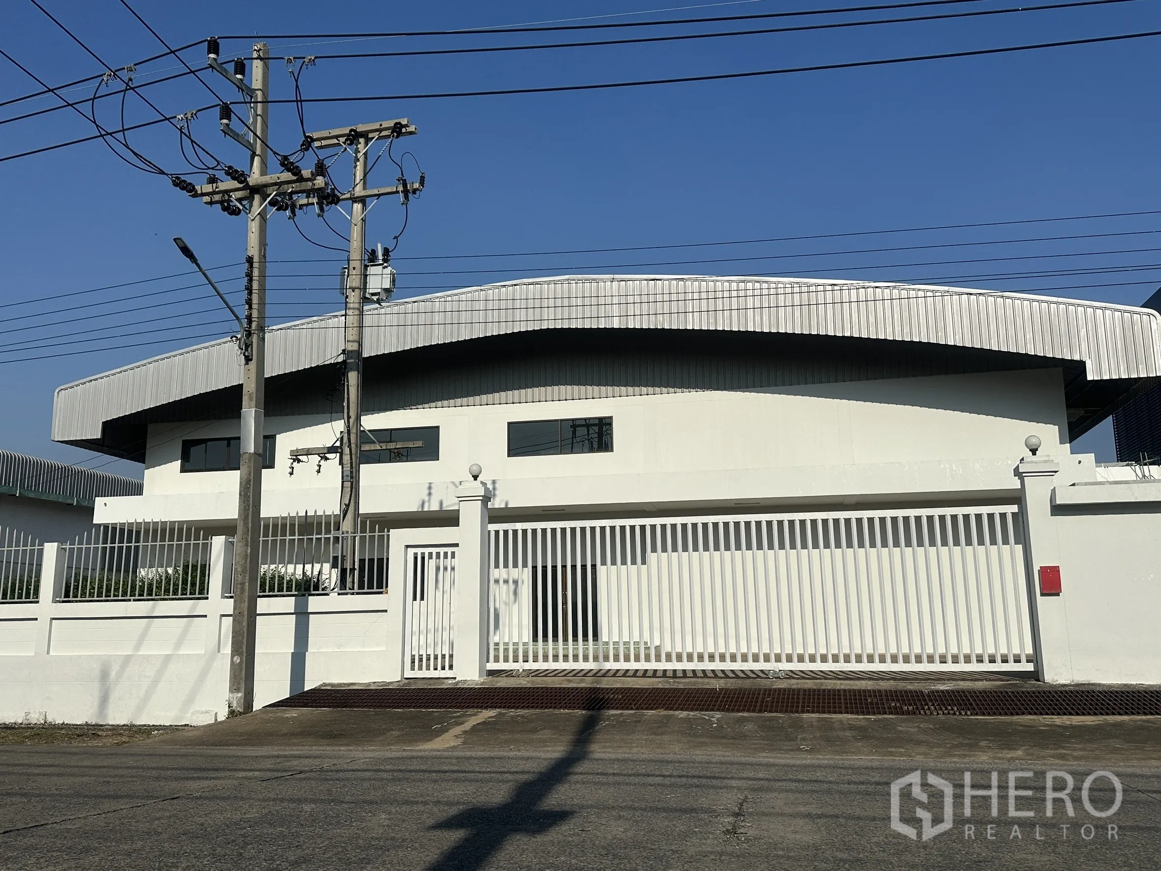 工厂 for sale in Khlong Luang, Pathum Thani - 正立面展示宽大的金属推拉门与车道坡道。