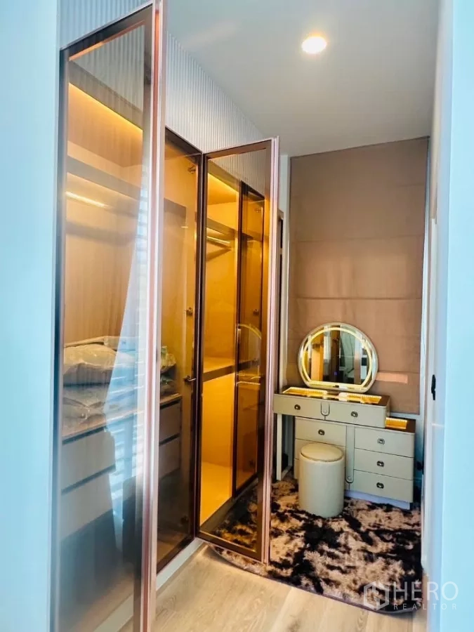 Detached House for rent or sale in Bang Kapi, Bangkok - Walk-in closet with illuminated glass wardrobes and vanity dressing table.