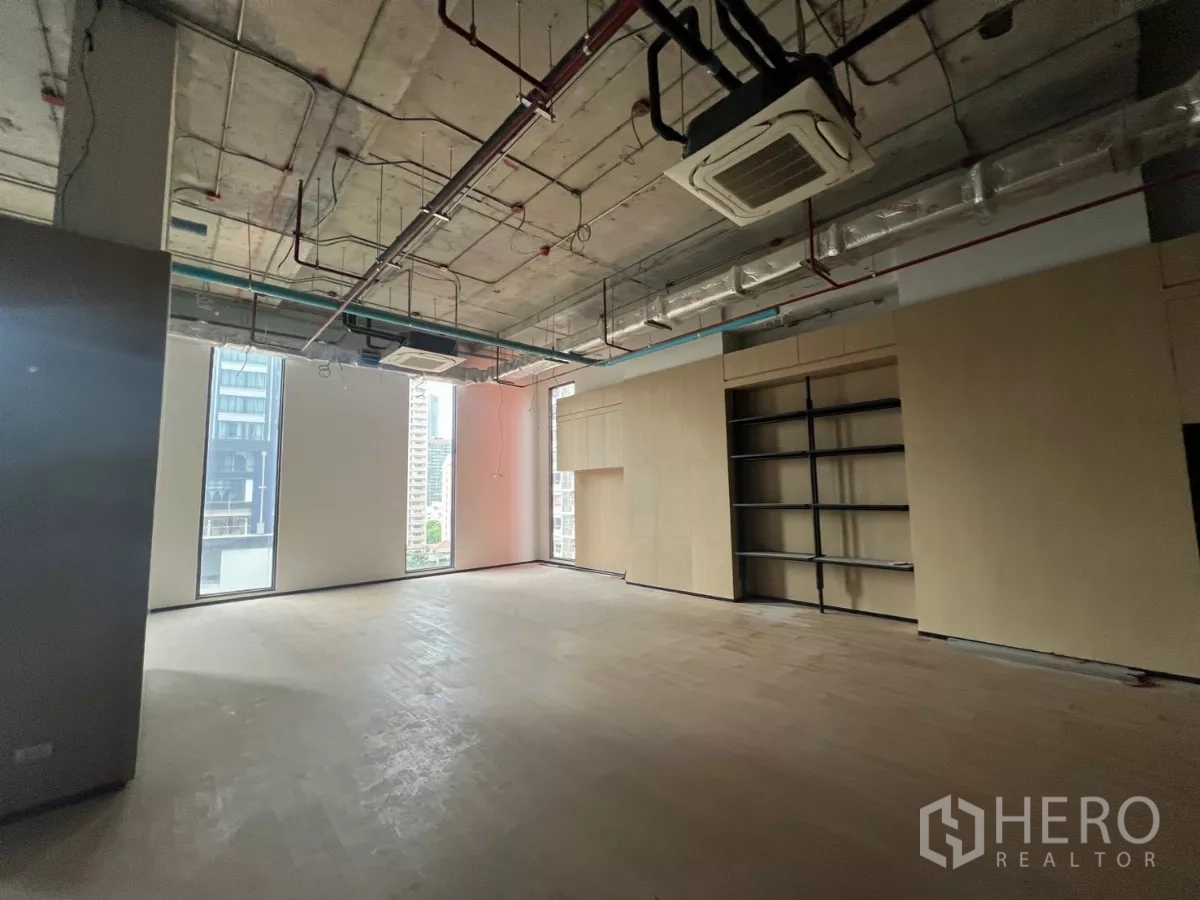Retail Space for rent - Spacious retail hall with full-height windows, industrial-style ceiling and display shelving.
