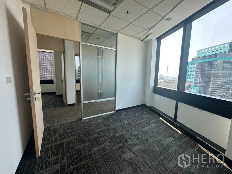 Office Space for rent in Khlong Toei, Bangkok - Private office with carpet flooring, glass partition and large windows overlooking the city.
