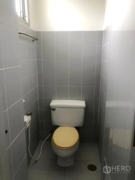 Factory for rent or sale in Bang Pa-in, Phra Nakhon Si Ayutthaya - Private toilet cubicle with ceramic tiles, flush toilet and bidet spray.