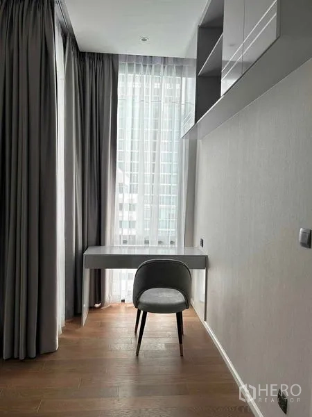 Condominium for rent in Pathum Wan, Bangkok - Work nook in a modern Lumphini condo for rent with desk, shelves and floor‑to‑ceiling window with city view.