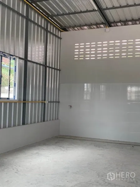 Warehouse for rent or sale in Thanyaburi, Pathum Thani - Bright storage bay with side windows, tiled lower walls and concrete floor.