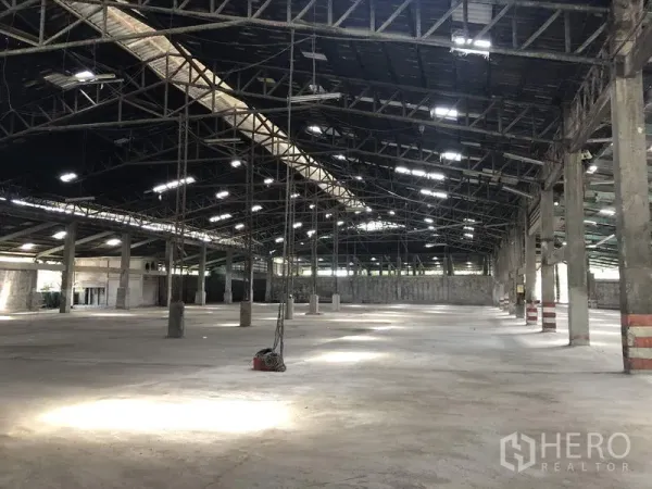 Warehouse for rent in Thanyaburi, Pathum Thani - Open-plan warehouse hall with wide clear spans, hanging lights and durable concrete flooring.