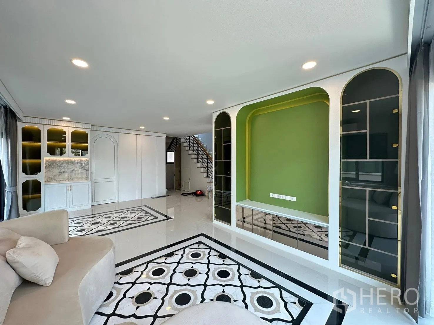 Detached House for rent in Bang Phli, Samut Prakan - Bright living room with patterned marble-look floor, curved sofa, and green TV feature wall.