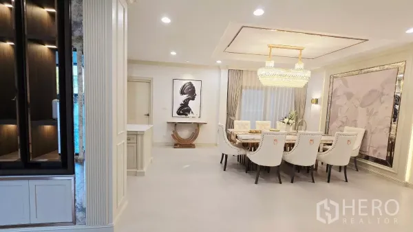Detached House for rent in Prawet, Bangkok - Elegant dining room featuring a long marble table, upholstered chairs and a chandelier.