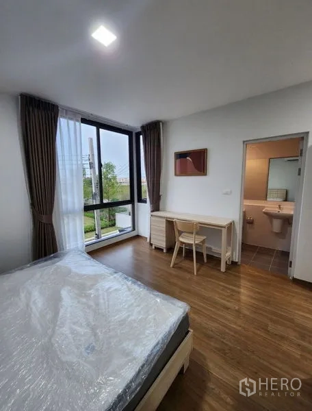 联排别墅 出租在Bang Phli, Samut Prakan - 主卧配落地窗、书桌与套内卫生间，可眺望绿地。
