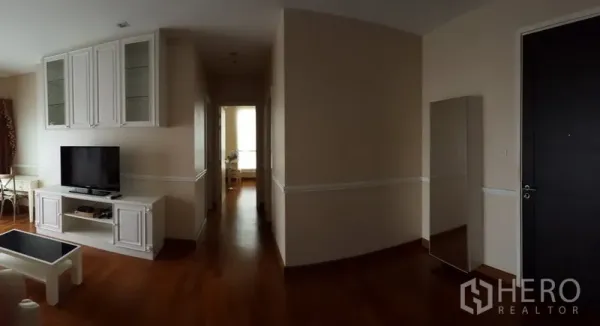 Condominium for rent in Bang Rak, Bangkok - Spacious entry and hallway leading to bedrooms, TV unit and full-length mirror, wood floors.