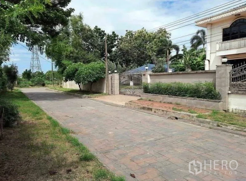 Detached House for sale in Prawet, Bangkok - Front gate and wide driveway leading into the detached house.