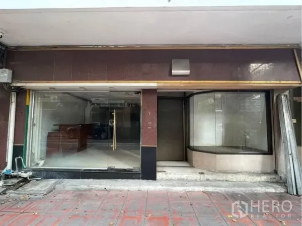 Shophouse for rent in Bang Rak, Bangkok - Street-level shophouse facade with wide glass storefront and curved display window in Silom.