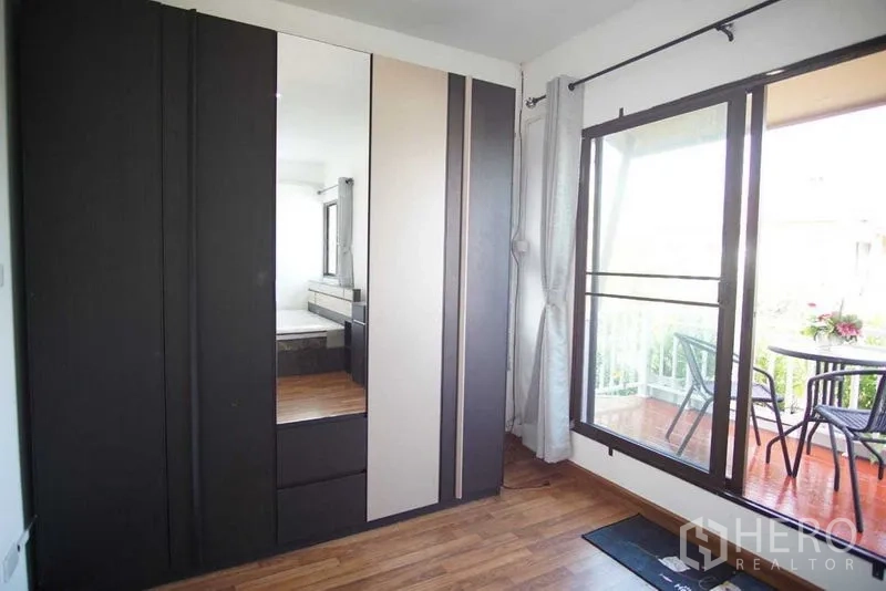 Townhouse for rent in Suan Luang, Bangkok - Bedroom corner with large wardrobe and sliding door to the balcony.
