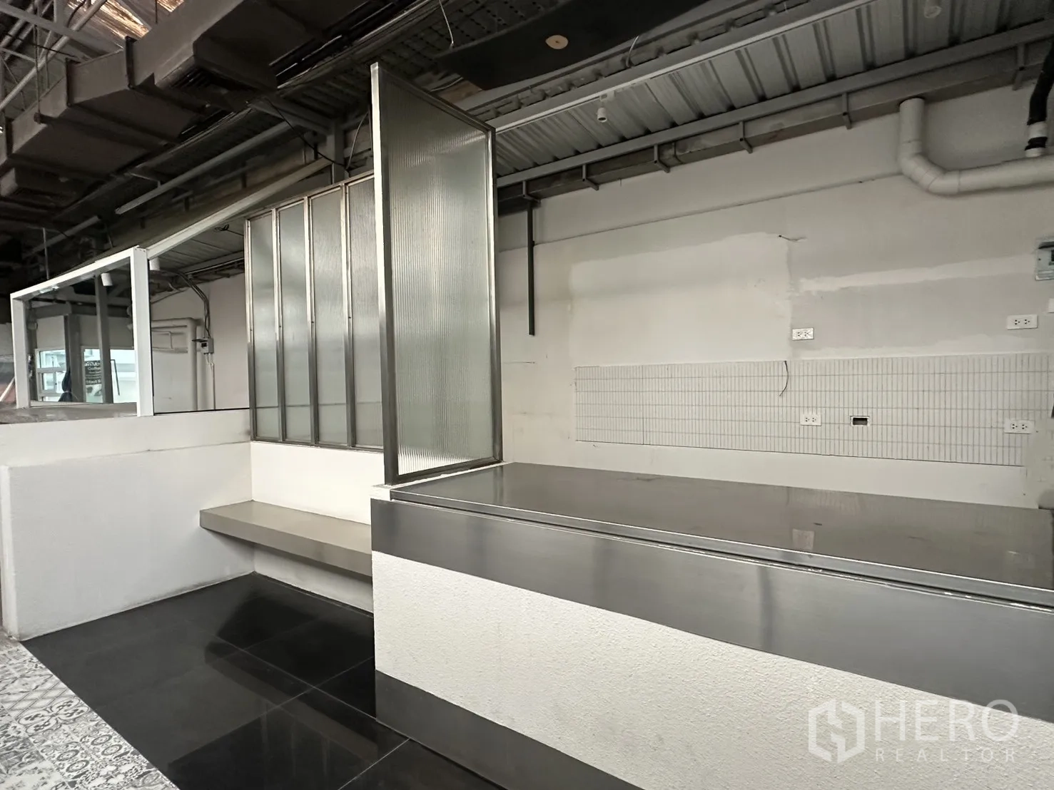 Retail Space for rent in Bang Rak, Bangkok - Industrial retail interior with stainless counter, ribbed-glass partitions and an exposed ceiling.