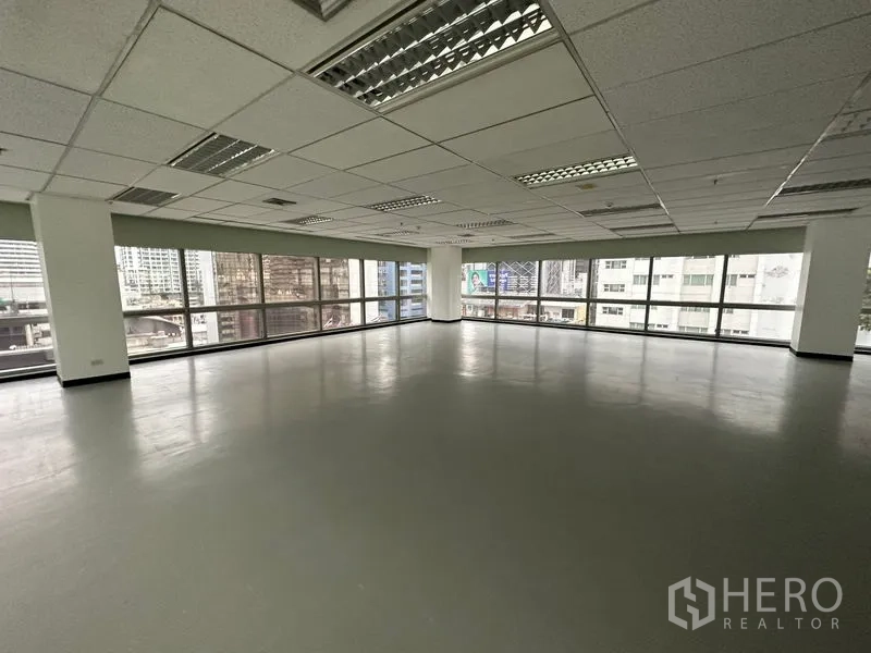 Office Space for rent - Spacious corner workspace with grid ceiling lights and skyline outlook.