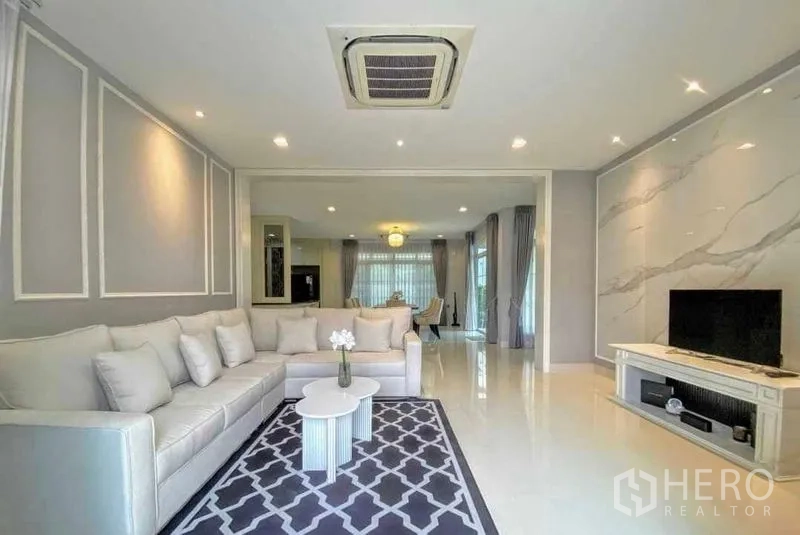 独立式住宅 出租在Bang Khen, Bangkok - 客厅带特色墙、地毯和电视柜。