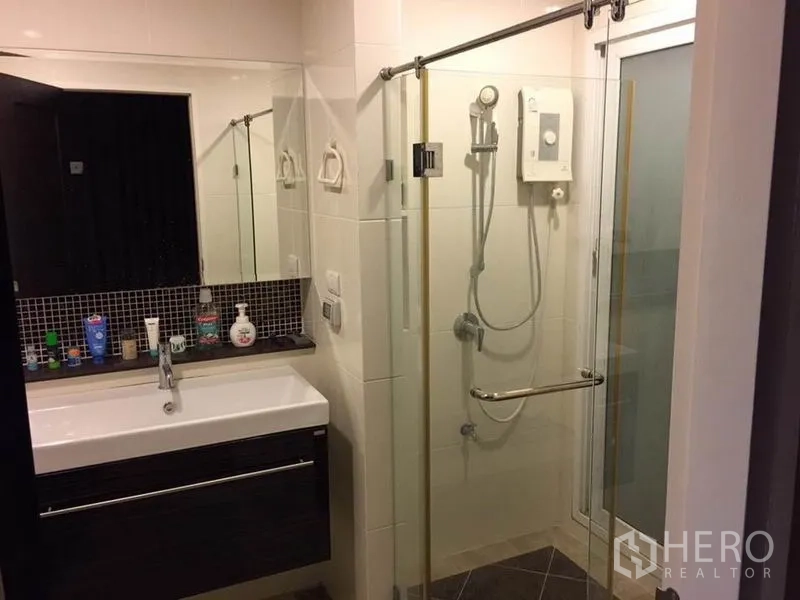 Detached House for rent or sale in Khlong Toei, Bangkok - Modern bathroom with glass-enclosed shower, water heater and sleek vanity cabinet.