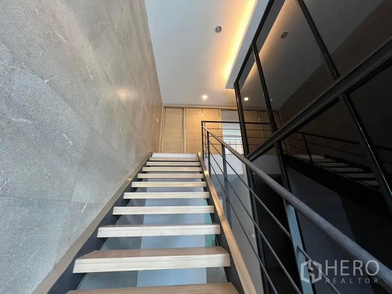 Home Office for rent in Bueng Kum, Bangkok - Close-up of wooden treads and black railing on the feature stairs.