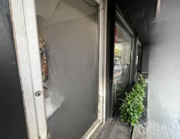 Shophouse for rent - Close-up of ground-floor display window with planter box and pavement.