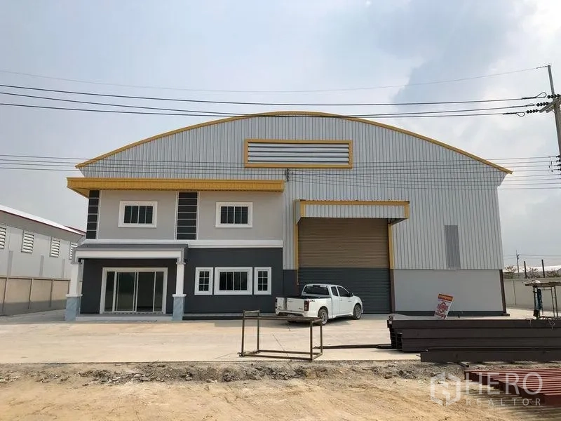 Factory for rent or sale in Bang Len, Nakhon Pathom - Full facade of the factory showing the office wing, loading bay and wide paved parking apron.