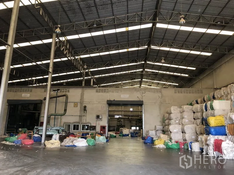 Factory for rent in Bang Bua Thong, Nonthaburi - Industrial hall with concrete floor, fire equipment and organized material stacks.