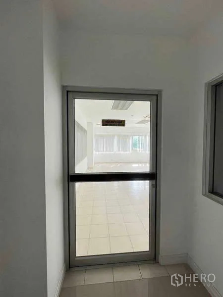 Warehouse for rent in Lat Krabang, Bangkok - Glass door entry into a bright office area with windows beyond.