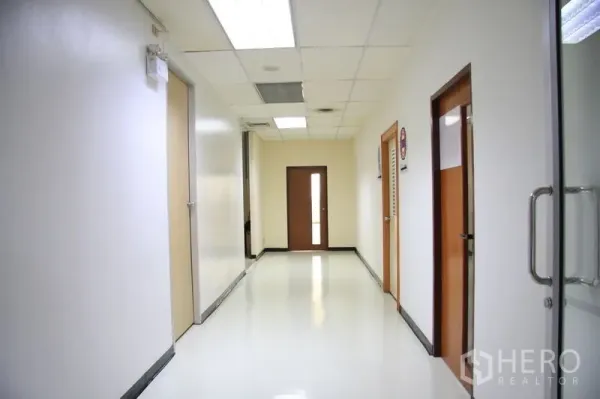 Office Space for rent in Chatuchak, Bangkok - Bright corridor with white walls, drop-ceiling lights, and multiple office doors.