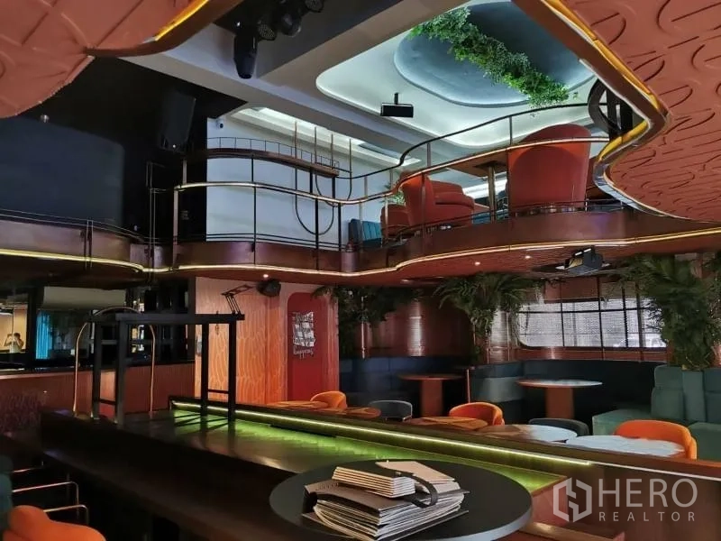 Retail Space for rent - Bar and lounge with gold railings, layered lighting, and elevated seating.