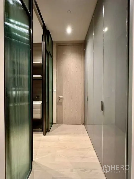 Condominium for rent or sale - Hallway with frosted glass partition and full-height wardrobes leading to a bedroom.
