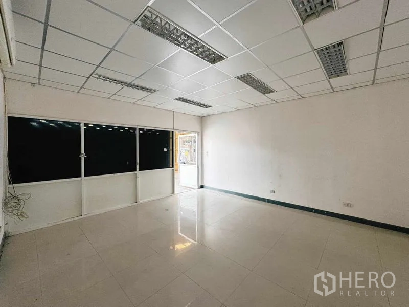 货栈 出租在Din Daeng, Bangkok - 立面展示办公室玻璃入口与金属包板及大门。