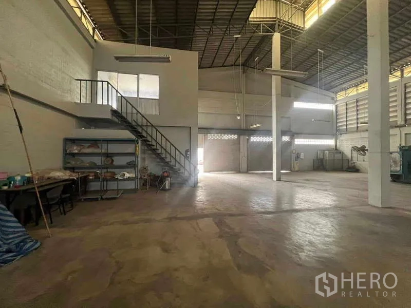 货栈 出租在Lam Luk Ka, Pathum Thani - 开放式生产区，楼梯通往夹层，置物架与混凝土地坪