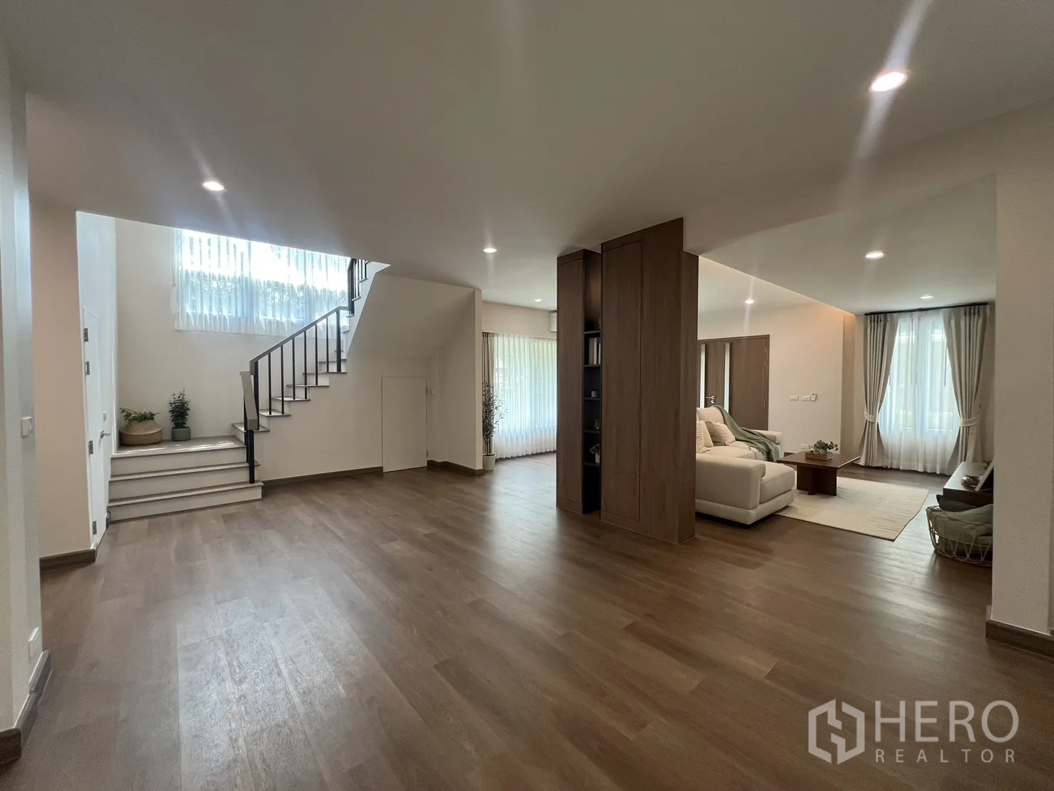 Detached House for rent in Mueang Samut Prakan, Samut Prakan - Wood partition bookshelf dividing bright living spaces.