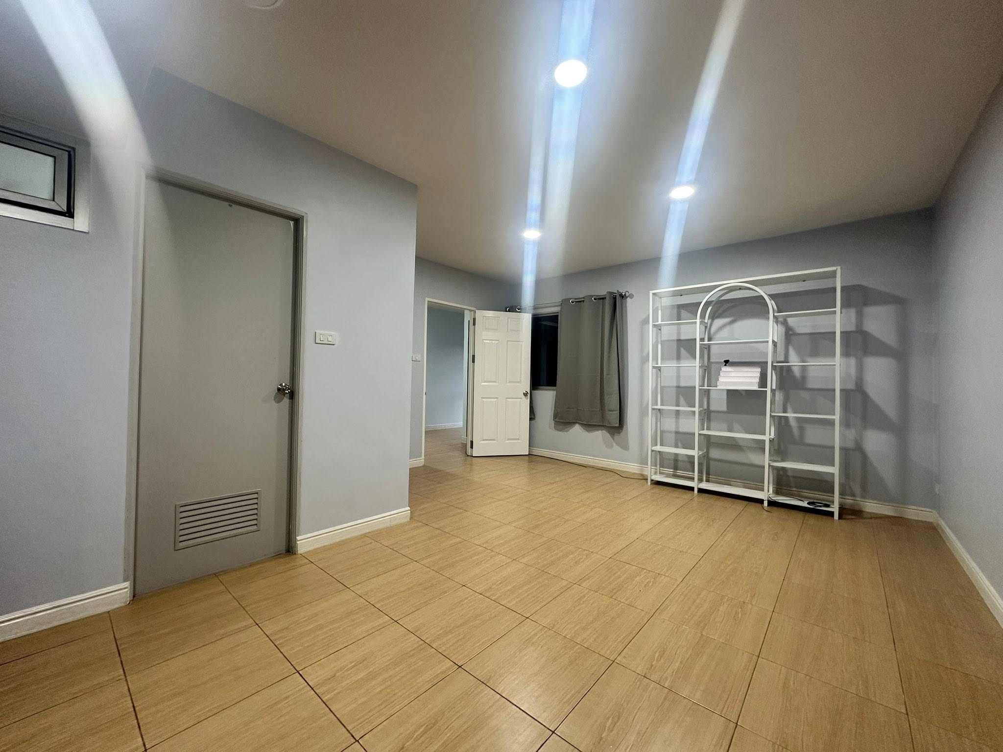 Home Office for rent in Wang Thonglang, Bangkok - Another view of the multipurpose room with metal shelving and curtained window.