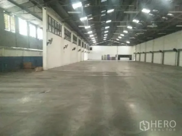 Warehouse for rent in Khlong Luang, Pathum Thani - Wide storage hall showing ventilation windows and roof lights along one side.