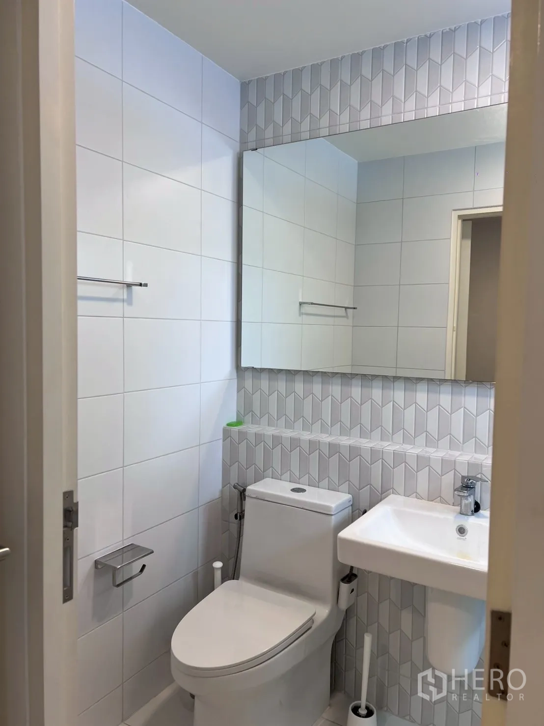 Townhouse for rent in Bang Phli, Samut Prakan - Guest bathroom with geometric wall tiles, toilet, and sink.
