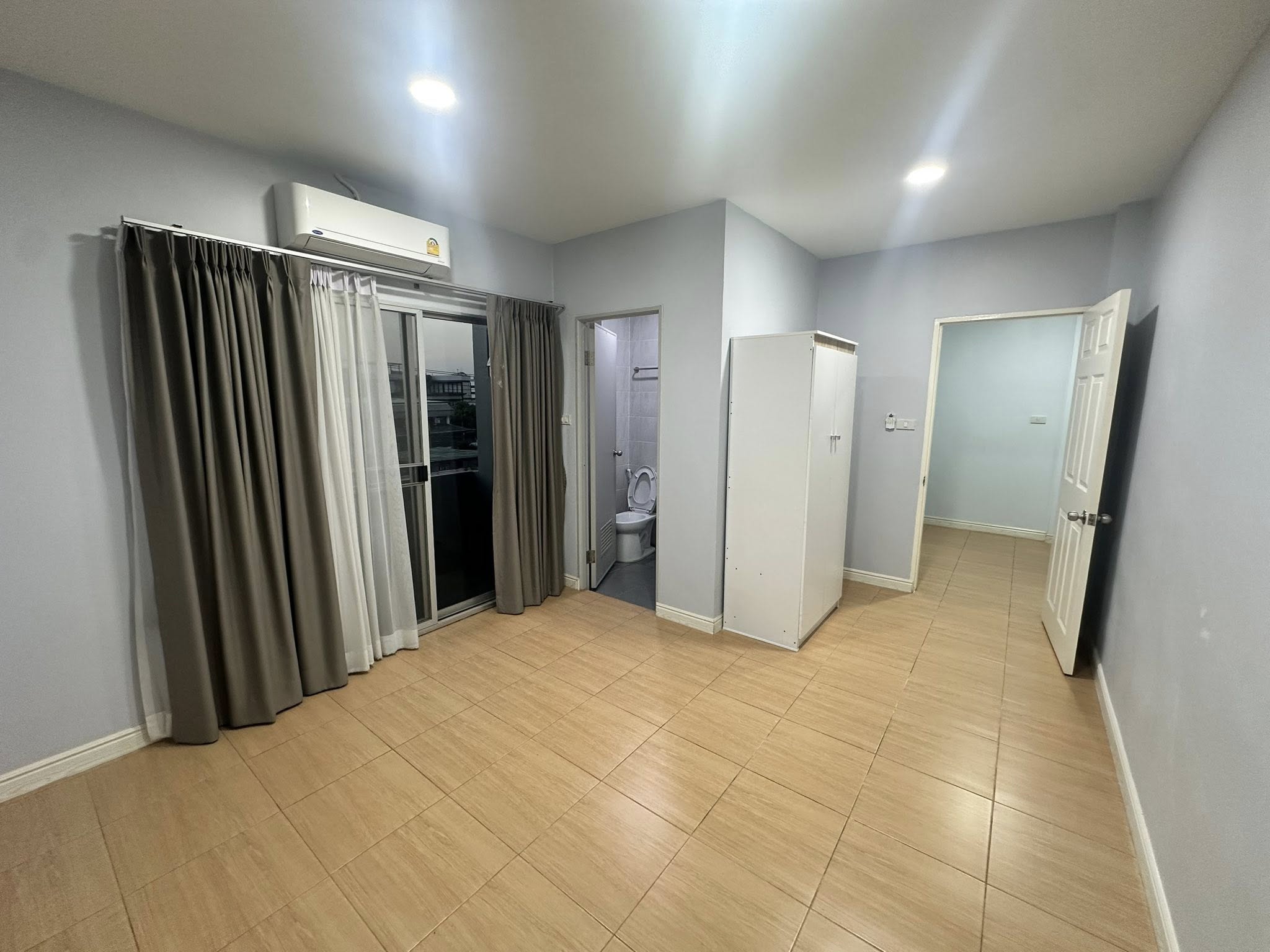 Home Office for rent in Wang Thonglang, Bangkok - Bedroom with balcony access, built-in air conditioner and ensuite bathroom.
