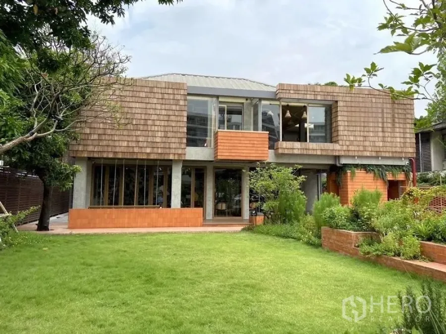 Retail Space for rent in Watthana, Bangkok - Modern two-storey retail building with wood-shingle cladding, large windows and a landscaped lawn in Ekkamai, Bangkok.