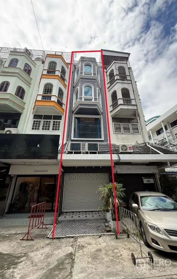 Shophouse for rent - Five-storey shophouse exterior with bay windows and roller shutter, outlined in red on a row of town buildings.
