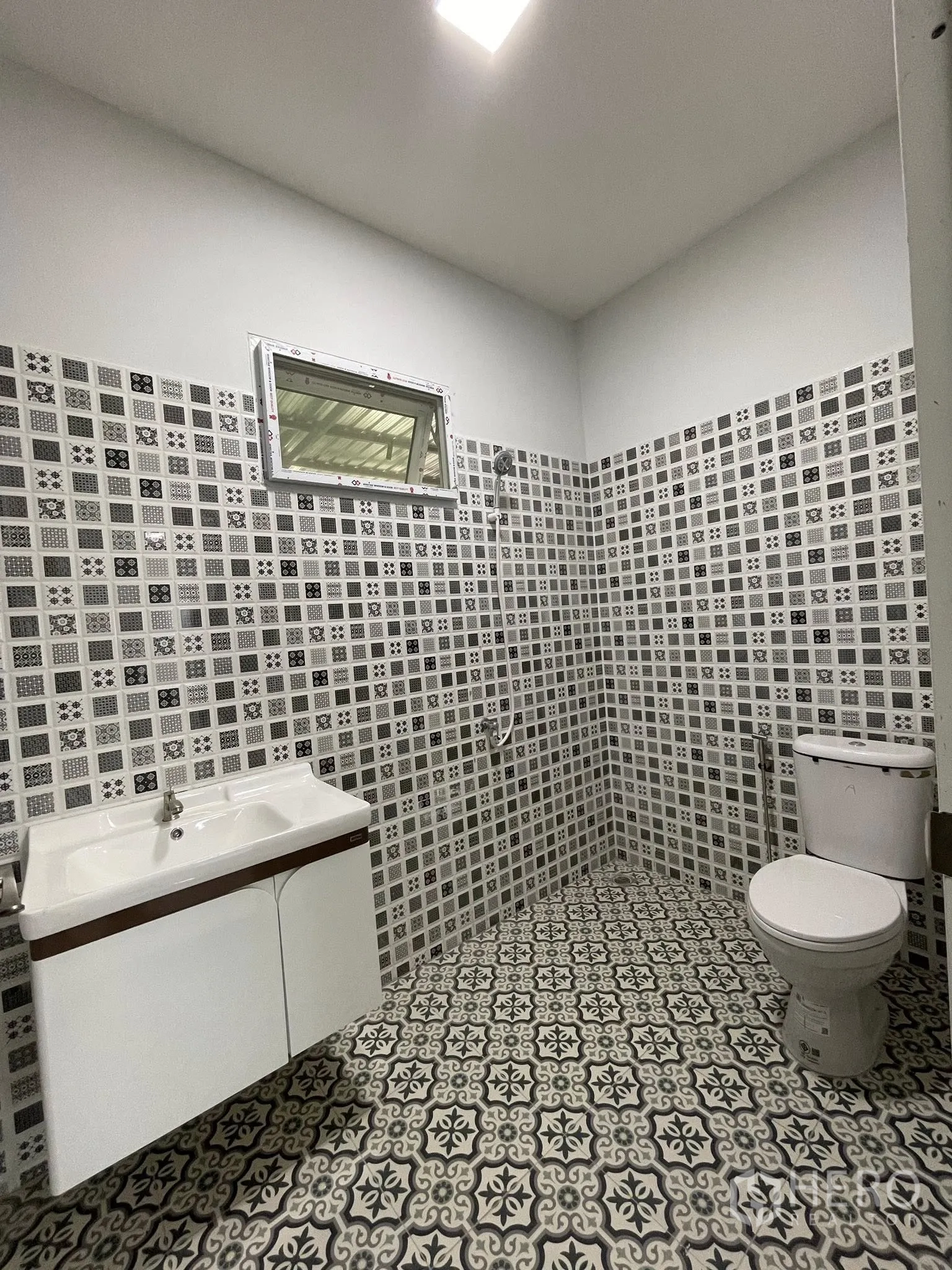 Factory for rent or sale in Bang Phli, Samut Prakan - Second bathroom with patterned wall and floor tiles, sink, and toilet.