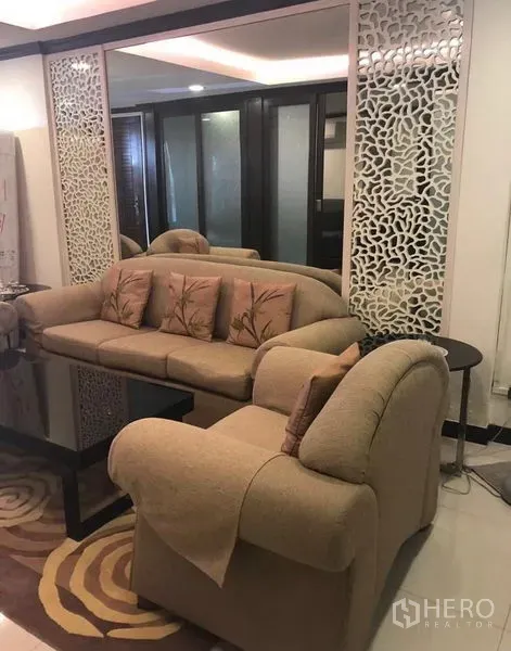 Townhouse for rent in Khlong Toei, Bangkok - Second sitting area with beige sofas, decorative mirrored panels, and recessed lighting.