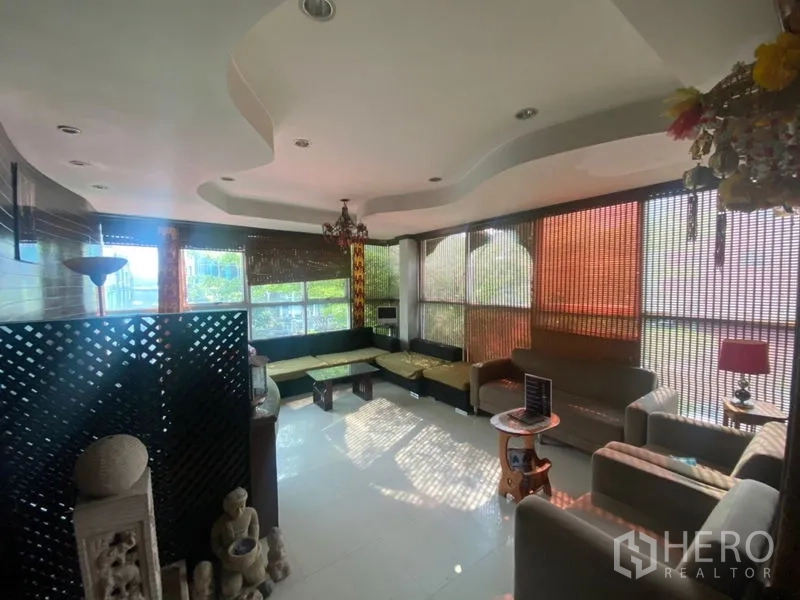 办公空间 出租在Khlong Toei, Bangkok - 转角休息区，落地窗、L形座椅与造型天花。